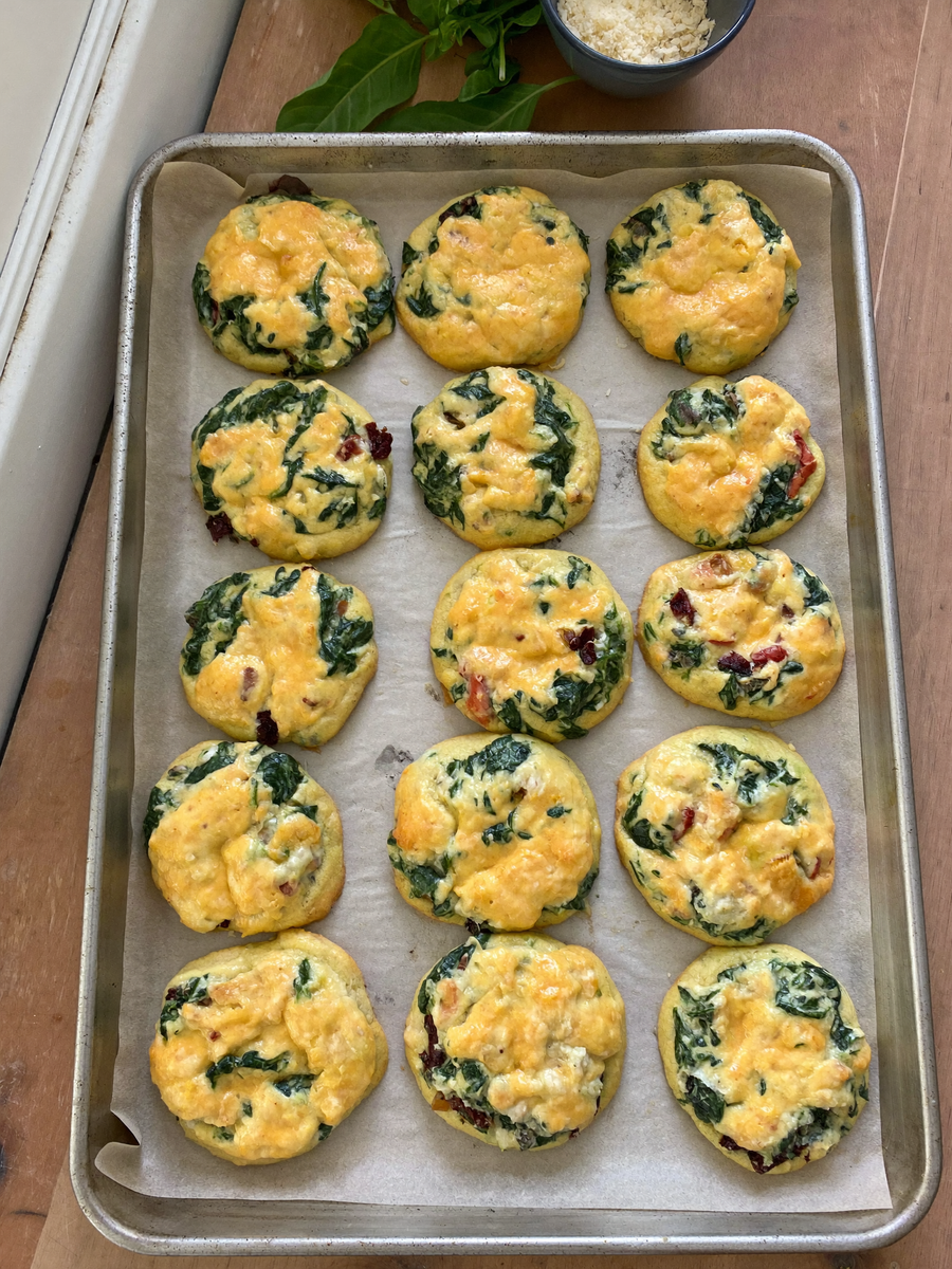 Keto sun-dried tomato and spinach egg biscuits on a baking sheet