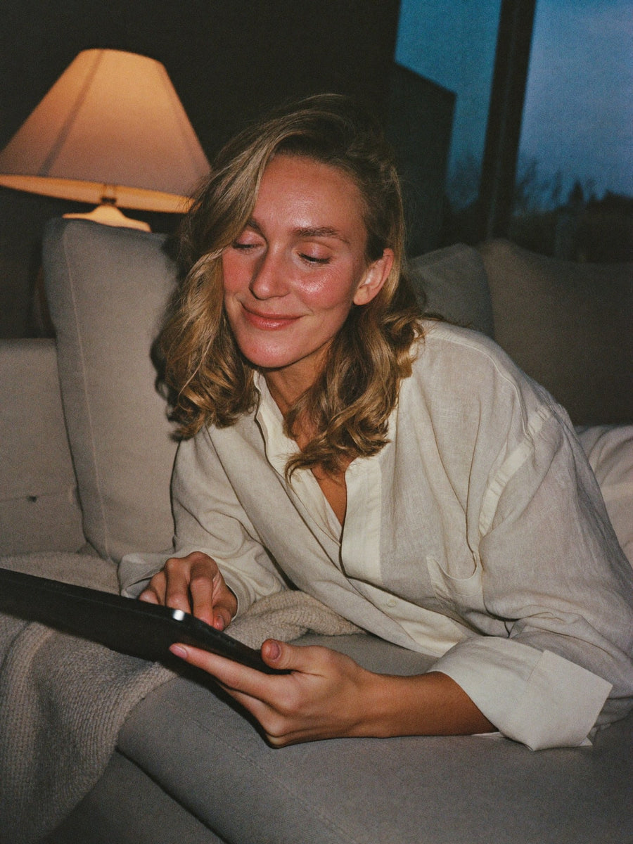 Woman relaxing on the sofa in the evening, choosing dinner on her tablet
